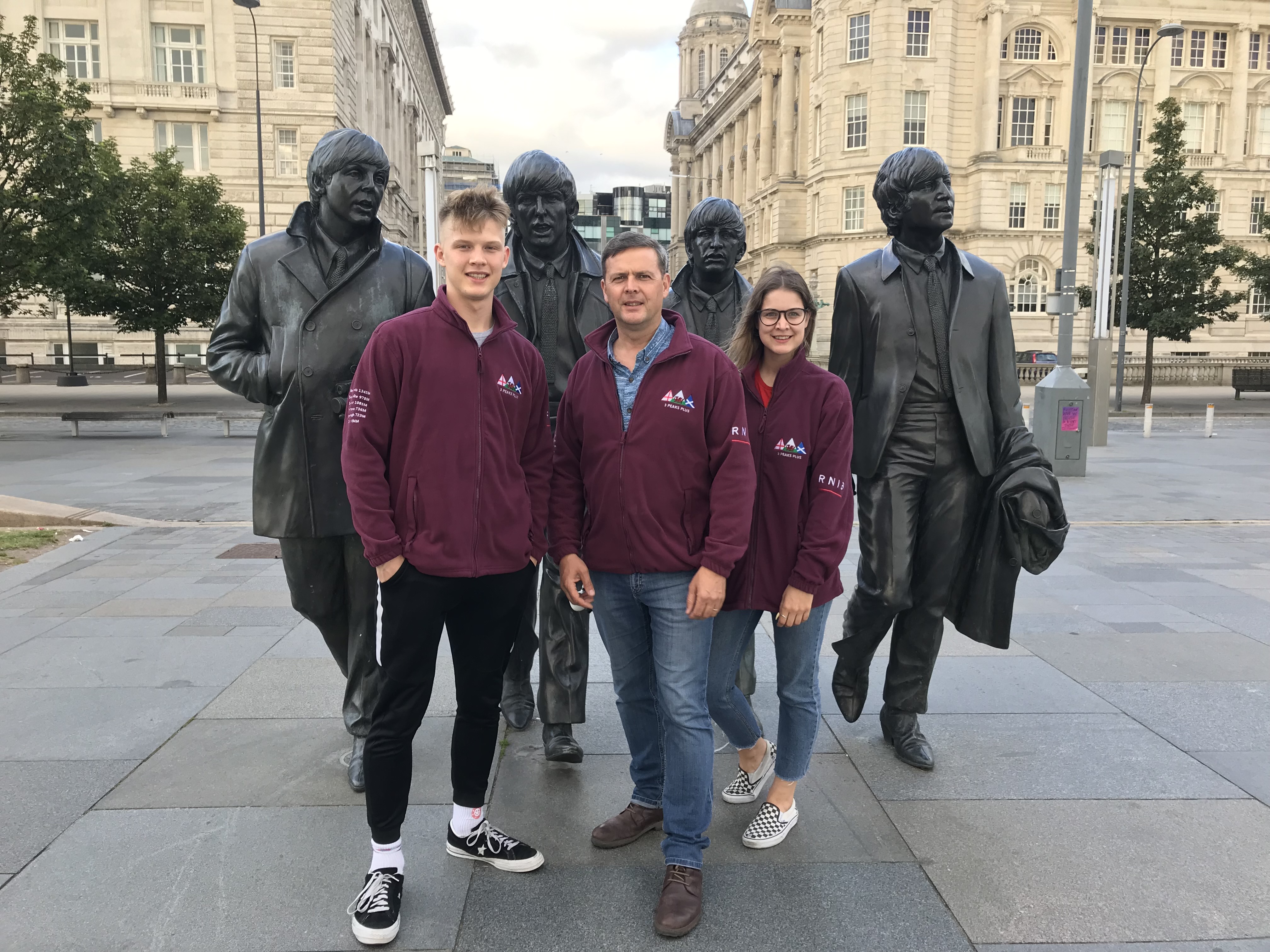 The statue of the iconic Beatles stands on Liverpool docks. Ollie, Laura dn I stand in front of them with our three red jackets.